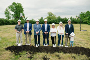 City Commissioners and Managers holding shovels beside the freshly turned dirt.